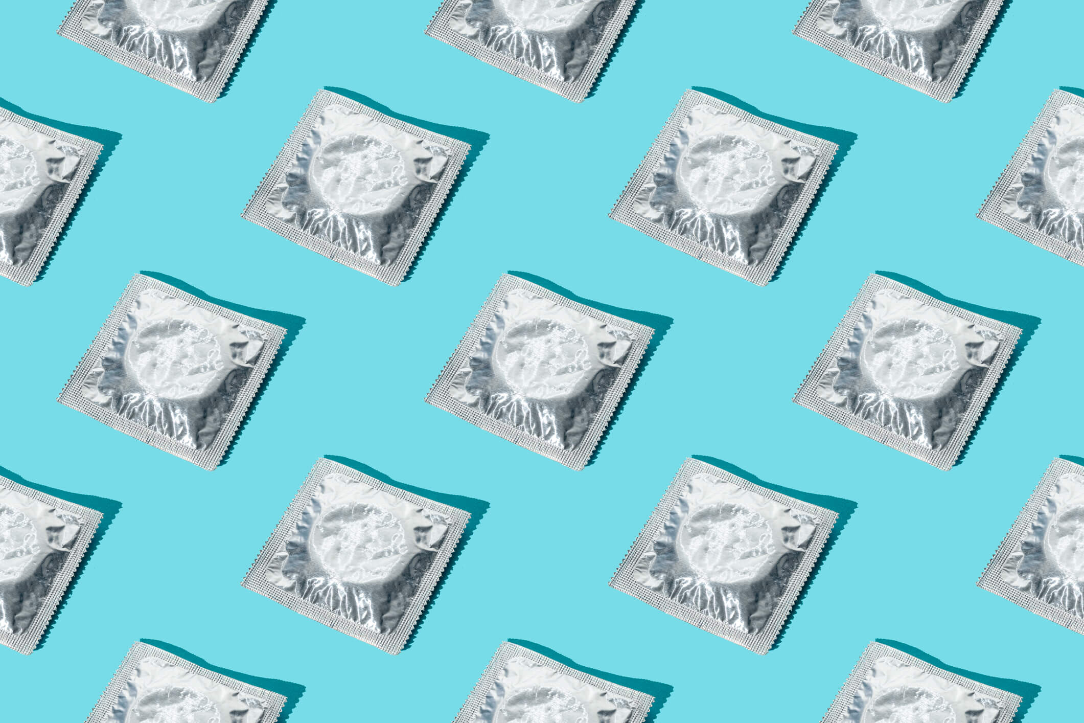 silver condoms on top of a light blue background