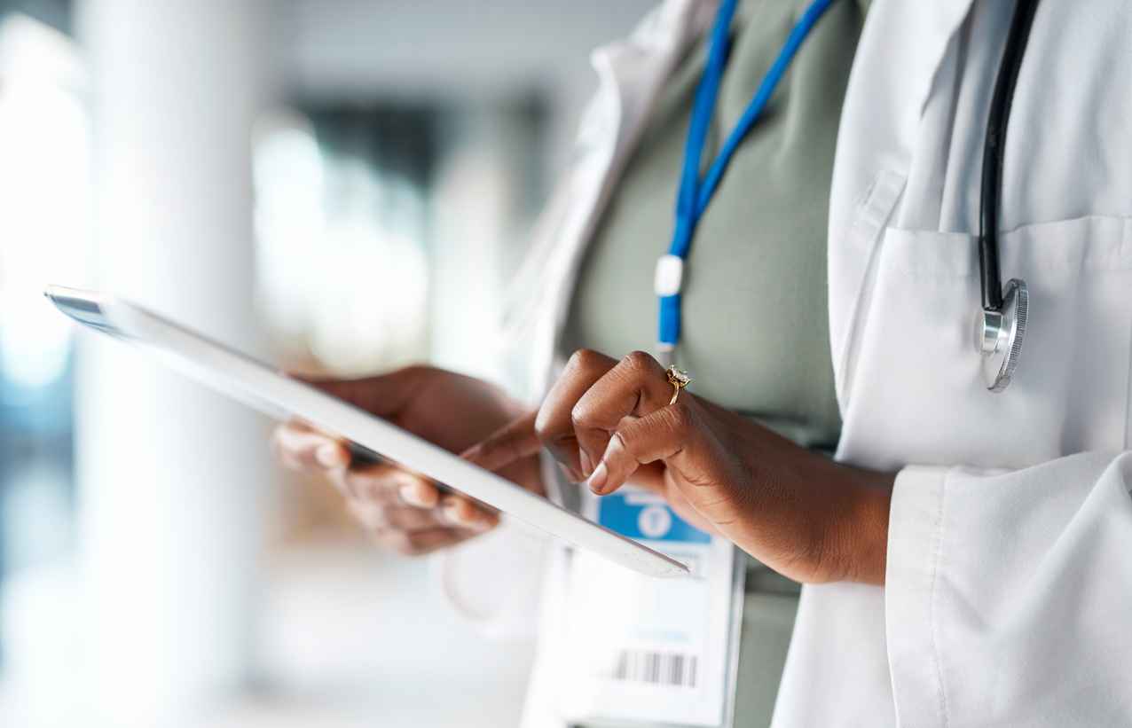 Healthcare, doctor and tablet in hands at hospital for telehealth, research and online prescription. Insurance, clinic and female with digital tech for medical report, data analysis and patient care