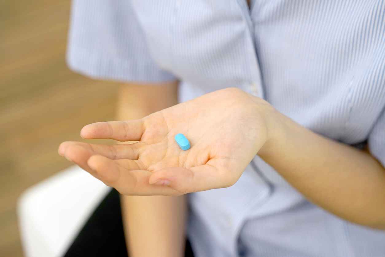 A girl holding a pill in her hand